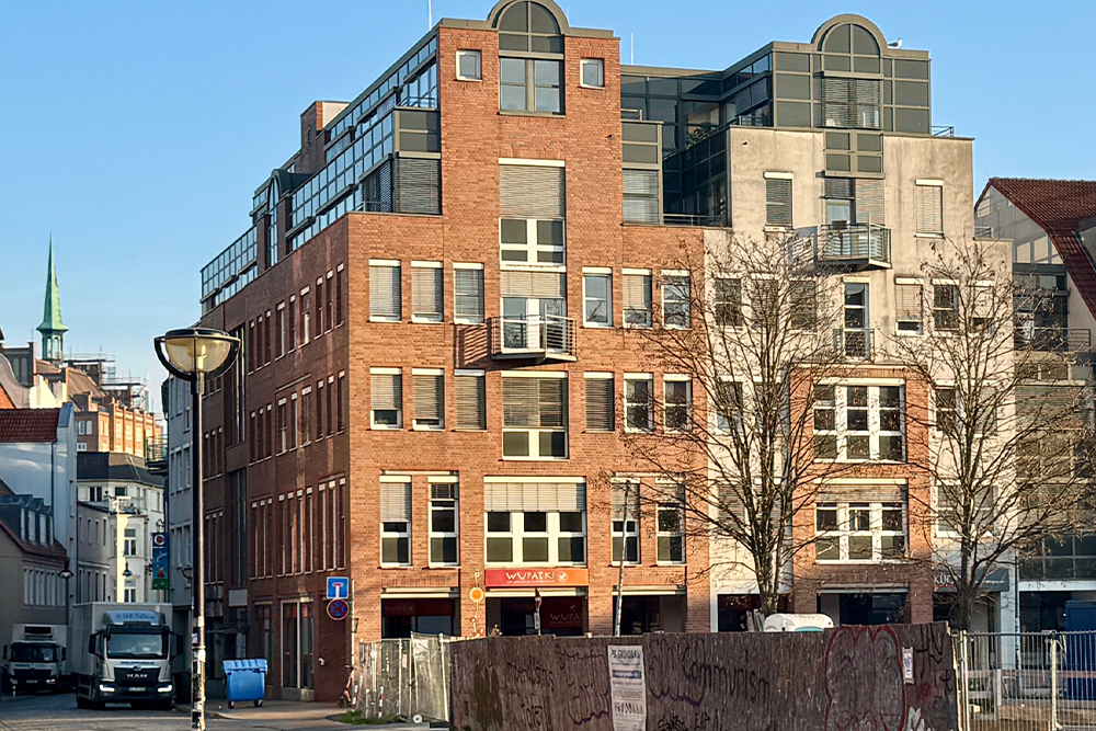 Außenansicht des Gebäudes in der Rungestraße 17, in dem Dr. Pech seine Praxis betreibt. Zu sehen ist ein rotes Backsteinhaus mit vielen Fenstern in der Innenstadt von Rostock.